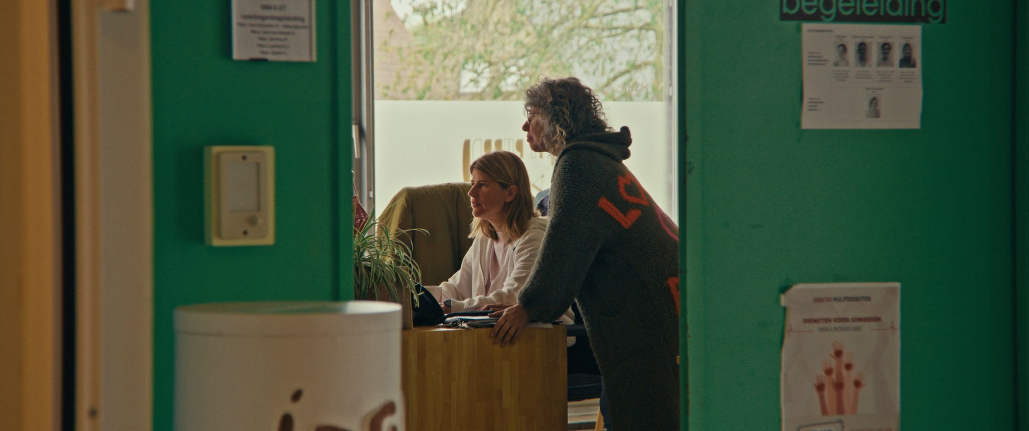 Twee vrouwen overleggen aan een bureau in het lokaal van de leerlingenbegeleiding.